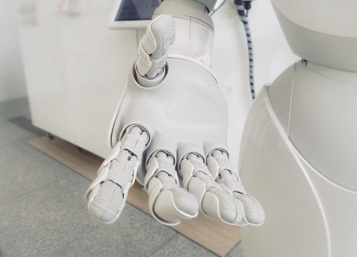 Comparison between a robot hand and a human hand, representing the different approaches in code translation.